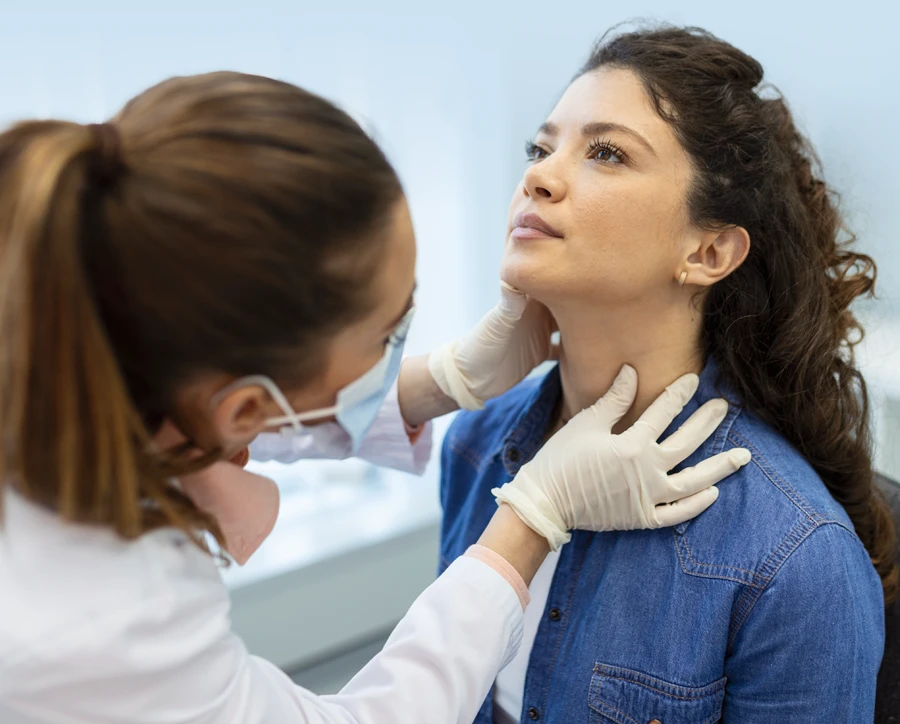 Doctor checking woman patient's throat