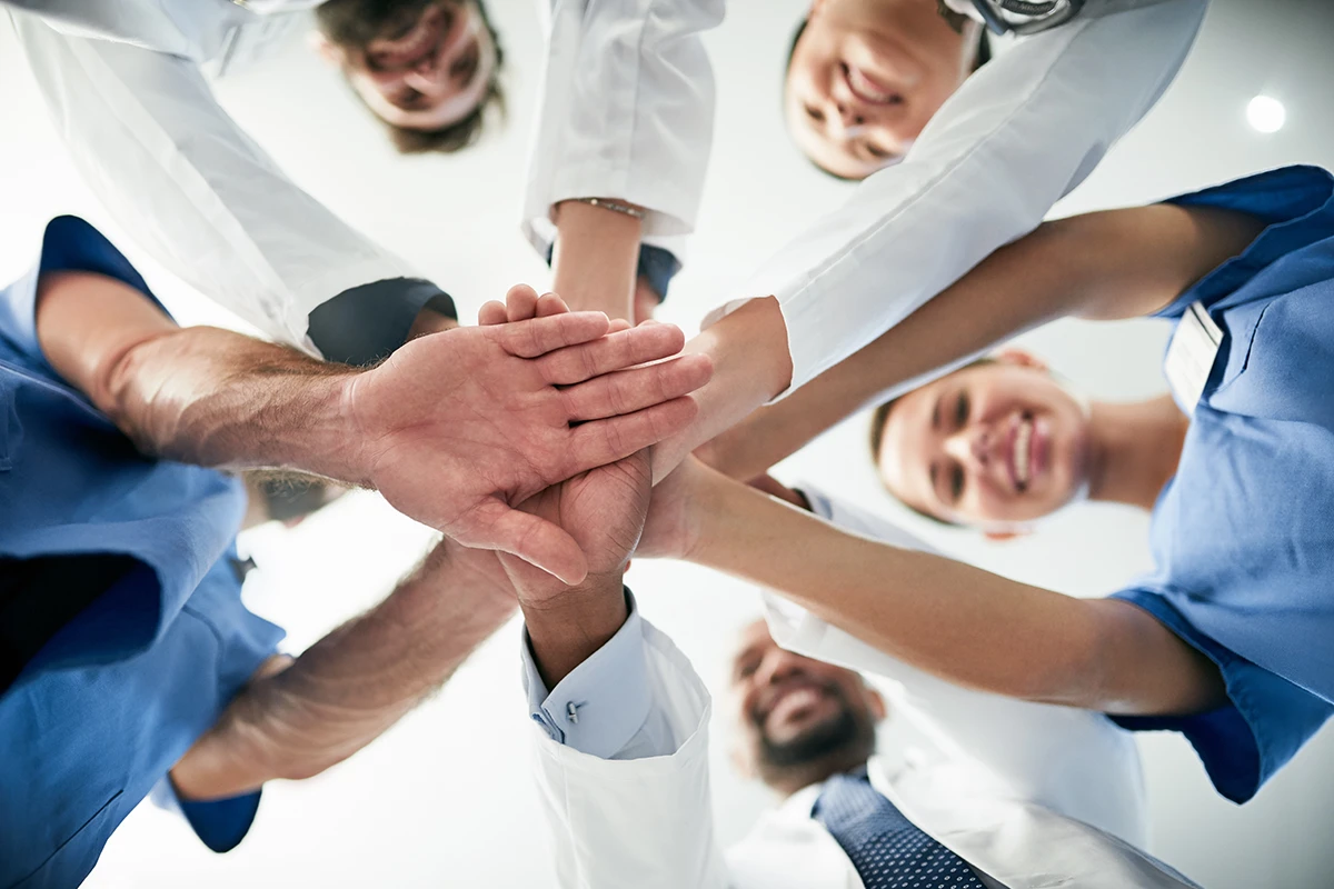 Diverse team of doctors joining hands